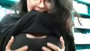 Desi sex student pulls T-shirt up to demonstrate XXX breasts in a library